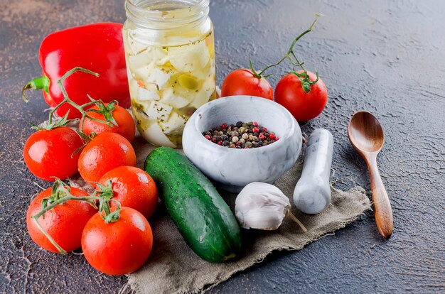 Feta piccante marinata in barattolo e verdure per insalata.