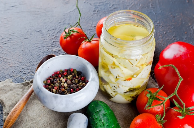 Feta piccante marinata in barattolo e verdure per insalata.