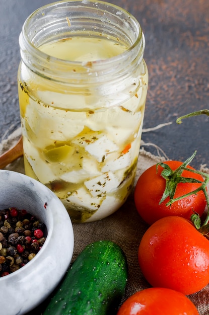 Feta piccante marinata in barattolo e verdure per insalata.