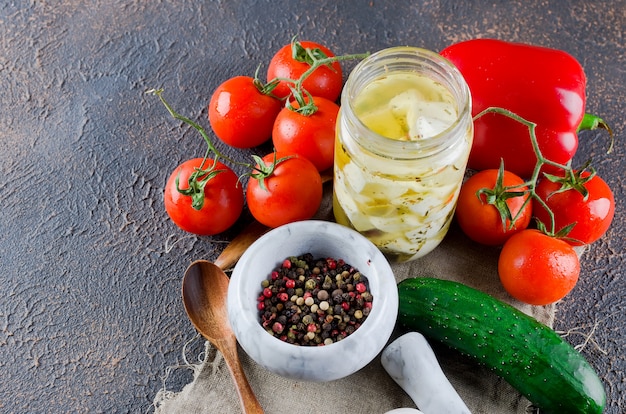 Feta piccante marinata in un barattolo e verdure per insalata.