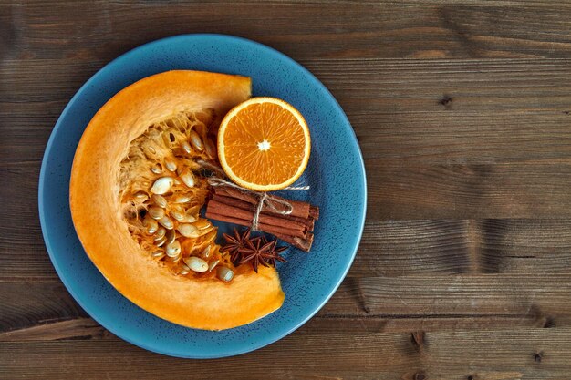 Fetta, arance e spezie organiche fresche della zucca su un piatto blu. Ingredienti della marmellata