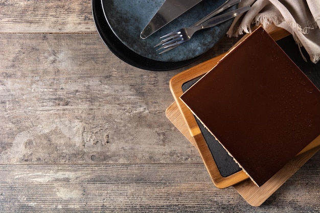 Fetta del dessert della torta dell'opera sulla tavola di legno