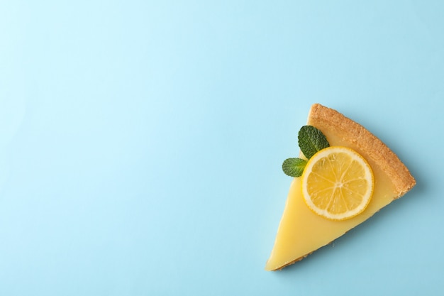 Fetta della crostata al limone sull'azzurro, spazio per testo