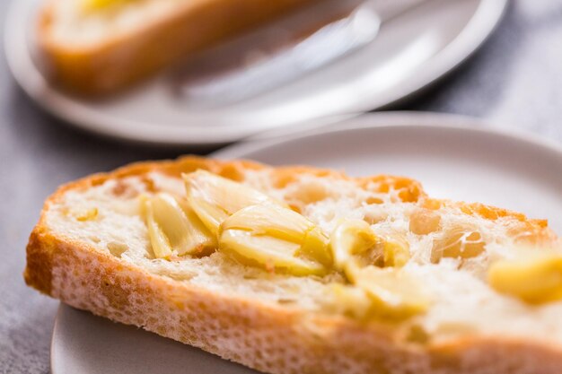 Fetta di ciabatta appena sfornata con spalmata di aglio al forno.