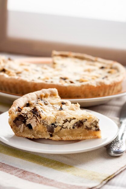 Fetta di crostata di pollo con funghi e formaggio su un piatto