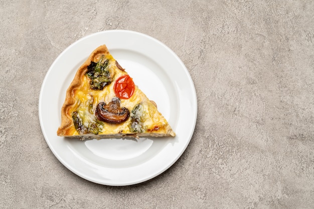 Fetta di crostata o torta casalinga tradizionale della quiche del pollo degli spinaci sul piatto