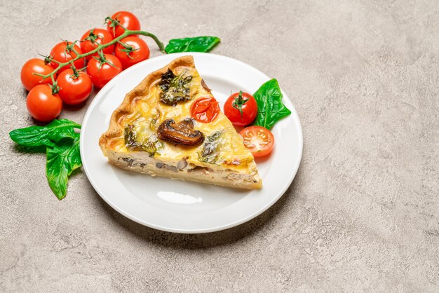 Fetta di crostata o torta casalinga tradizionale della quiche del pollo degli spinaci sul piatto