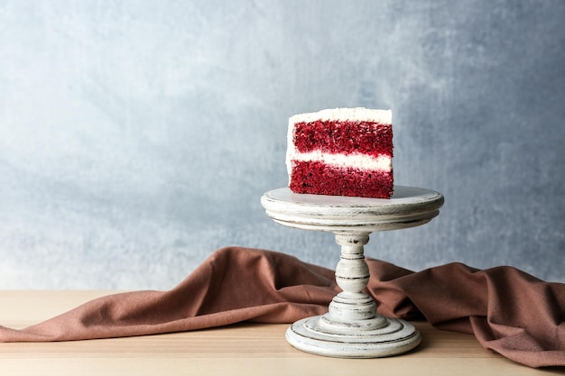 Fetta di deliziosa torta di velluto rosso su supporto in legno