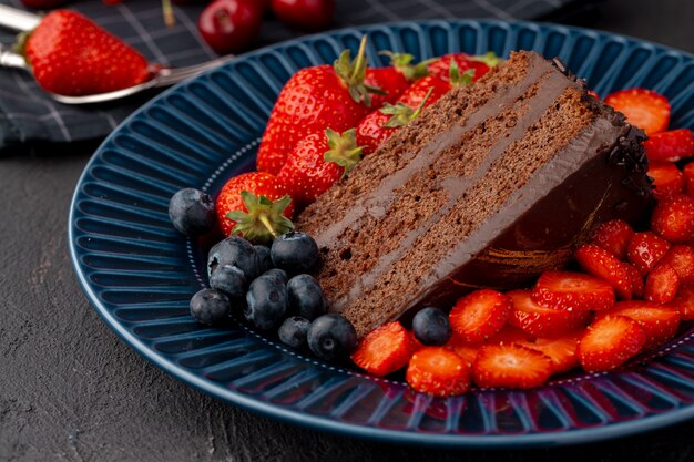 Fetta di gustosa torta al cioccolato con fragole tagliate