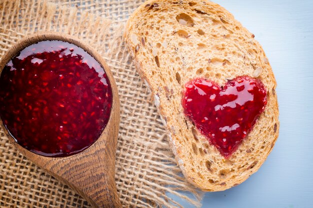 Fetta di pane con marmellata a forma di cuore.