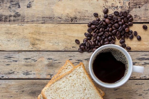 Fetta di pane e chicchi di caffè sulla tavola di legno