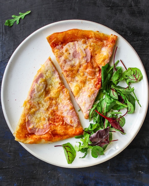 fetta di pizza e foglie di insalata in un piatto