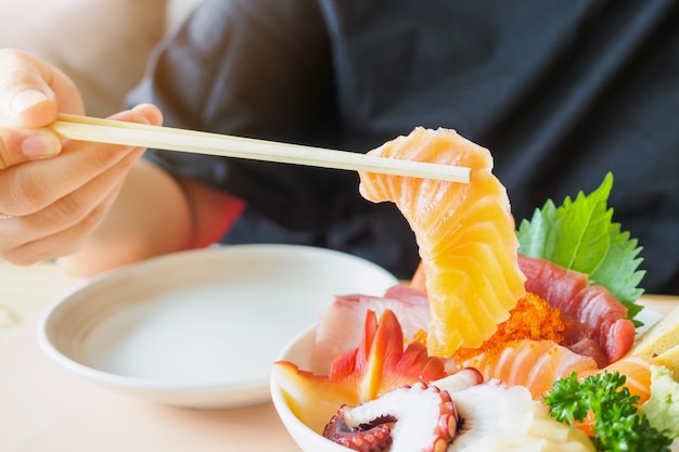 Fetta di salmone in bacchette, mangiare cibo giapponese Sashimi Rice Bowl Chirashi Don