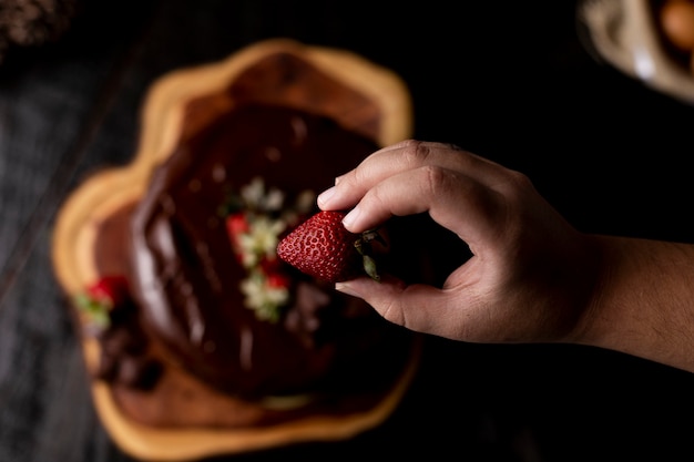 Fetta di torta al cioccolato artigianale con gustose fragole sul tavolo