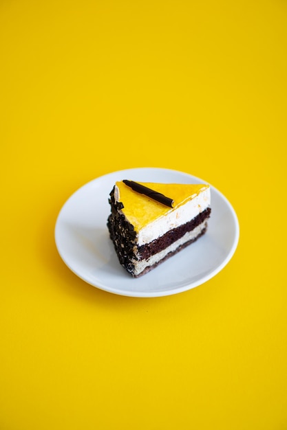 Fetta di torta al cioccolato con gelatina d'arancia superiore su sfondo giallo piatto