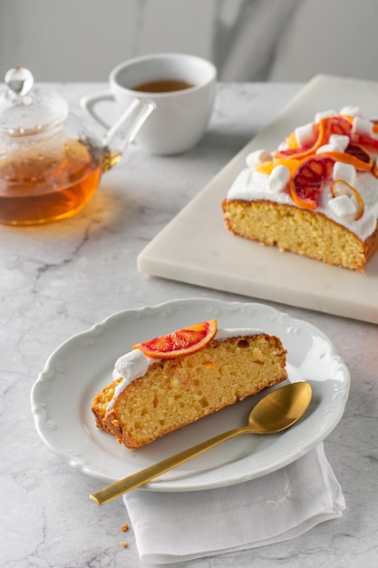 Fetta di torta all'arancia con arancia sanguinella fresca. Verticale