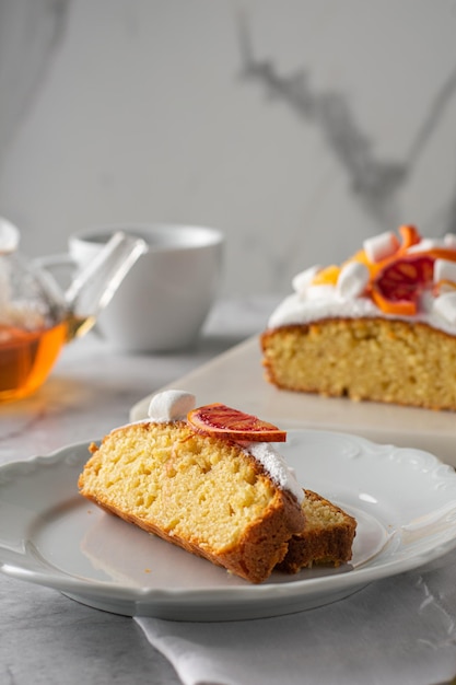 Fetta di torta all'arancia con arancia sanguinella fresca. Verticale