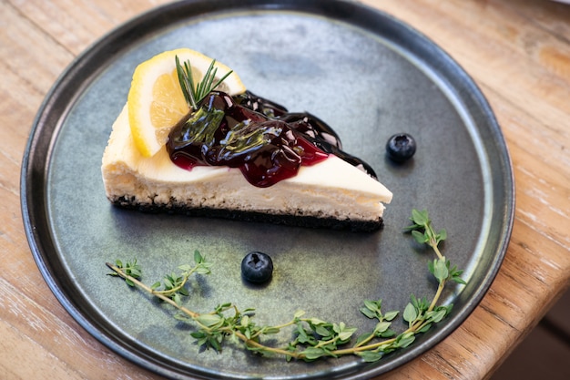 Fetta di torta di formaggio di mirtillo sulla banda nera.