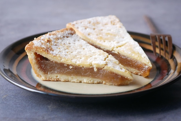 Fetta di torta di mele su un piatto su sfondo nero