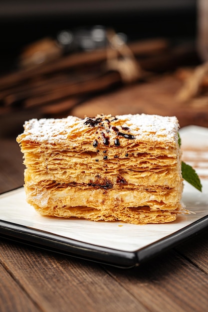 Fetta di torta napoleone su fondo in legno