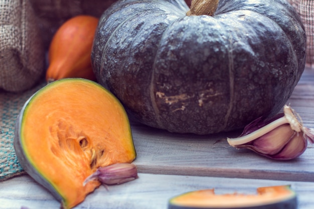 Fetta di zucca verde e altre zucche colorate con aglio