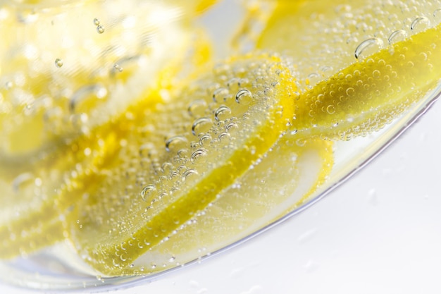 Fetta fresca del limone in acqua con le bolle