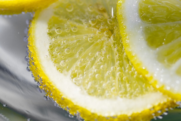 Fetta fresca del limone in acqua con le bolle