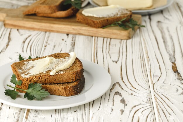 Fetta imburrata di pane di segale sulla tavola di legno