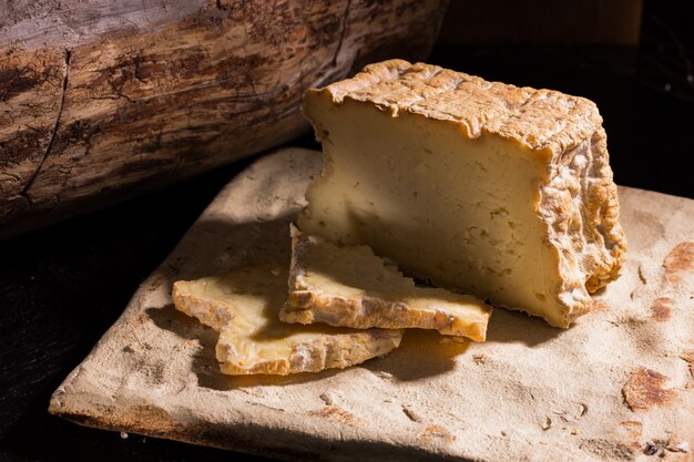 Fette appetitose di formaggio artigianale di fattoria sui bordi