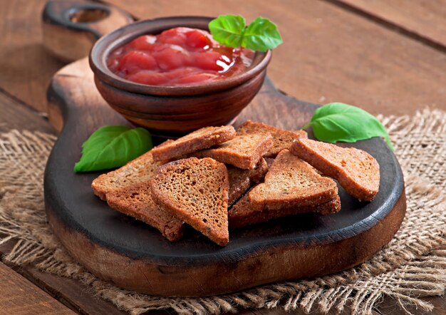 Fette biscottate di Rye con salsa piccante su un di legno