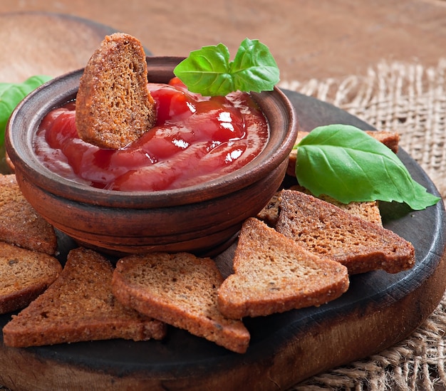 Fette biscottate di Rye con salsa piccante su una tabella di legno