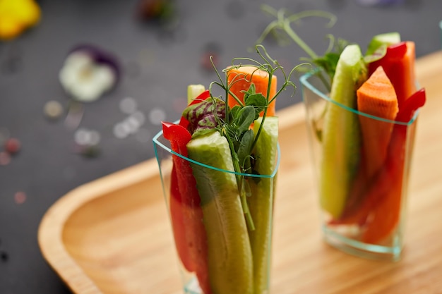 Fette colorate di verdure crude in bicchieri carote cetriolo peperone dolce Il concetto di dieta sana e cibo vegetariano
