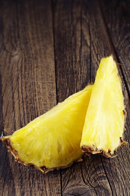 Fette di ananas mature su fondo di legno d'epoca