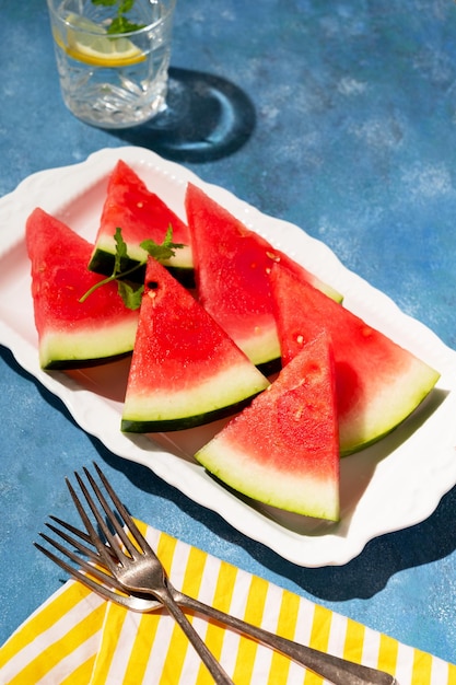 Fette di anguria in un piatto sfondo blu Cibo sano