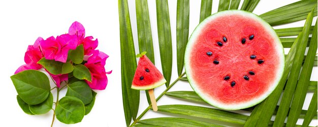 Fette di anguria su foglie di palma tropicali e fiori di bouganville rossa su bianco