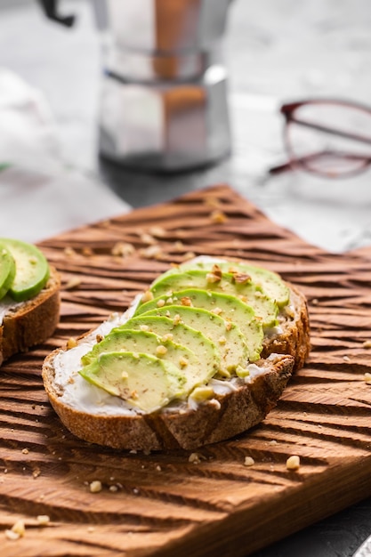 Fette di avocado su pane tostato con noci. La colazione e il concetto di cibo sano.