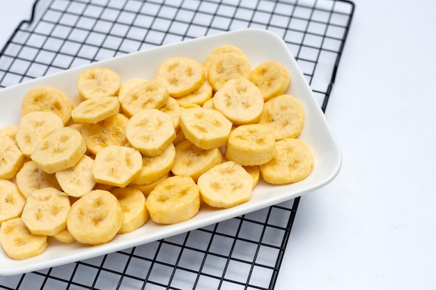 Fette di banana in piatto bianco