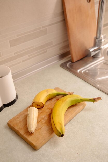 Fette di banana matura sbucciate di banana gialla matura sul tavolo della cucina