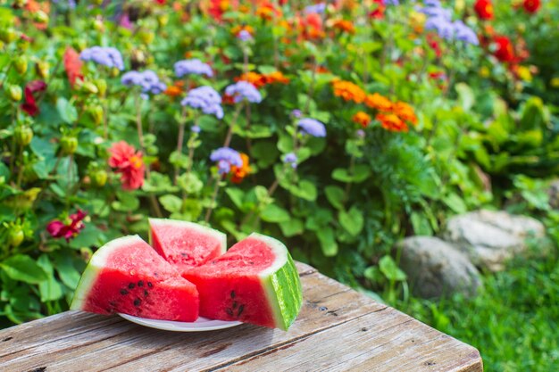 Fette di cocomero rosso fresco su uno sfondo di fiori Raccolta di cibo sano concept