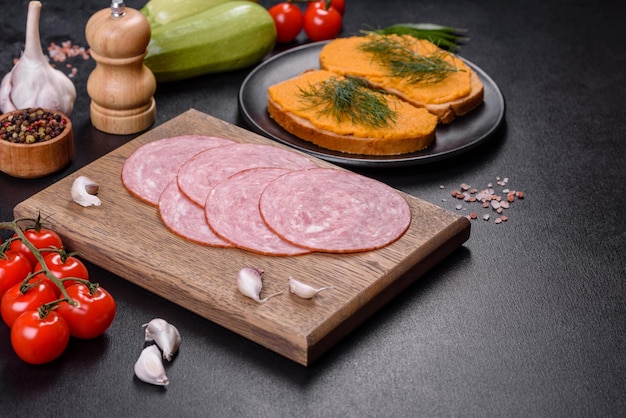 Fette di deliziosa salsiccia fresca su un tagliere di legno