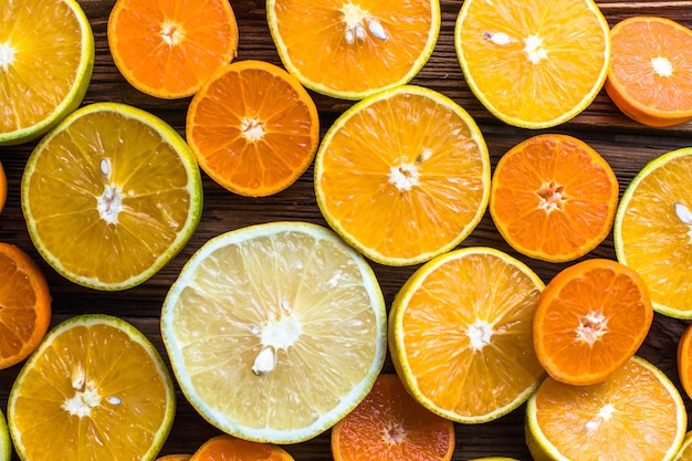Fette di frutta arancione a metà arancione su sfondo di legno