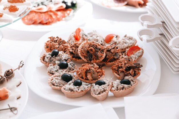 Fette di involtini di salmone di frittelle e funghi su un piatto da spuntino