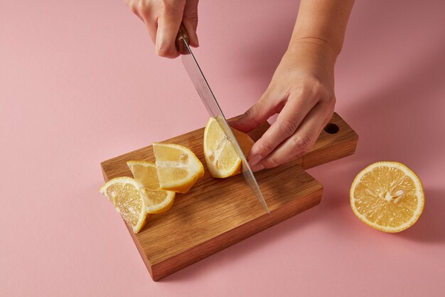 Fette di limone giallo fresco biologico su un tagliere di legno