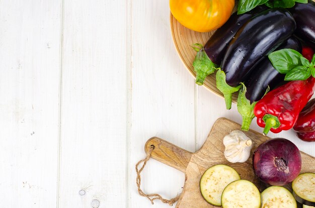 Fette di melanzane a fette su tavola di legno, verdure di stagione per la cottura. Foto dello studio.