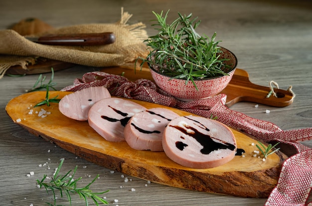 Fette di mortadella Bologna IGP su tagliere di legno