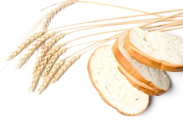 Fette di pane a fette e grano su un primo piano bianco del fondo