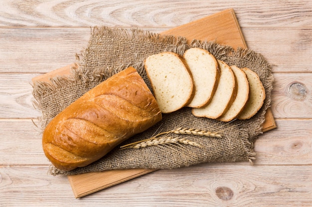 Fette di pane appena sfornato sul tagliere su sfondo bianco in legno vista dall'alto Pane affettato