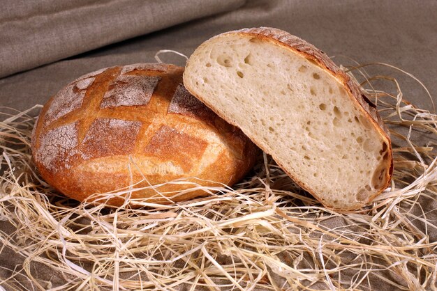 fette di pane bianco che giace nella paglia sulla tovaglia di lino grigio