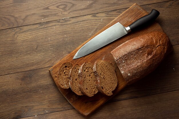 fette di pane di segale e un coltello primo piano, su un tagliere di legno