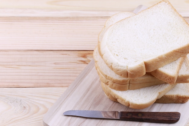 Fette di pane impilate su un tagliere di legno.